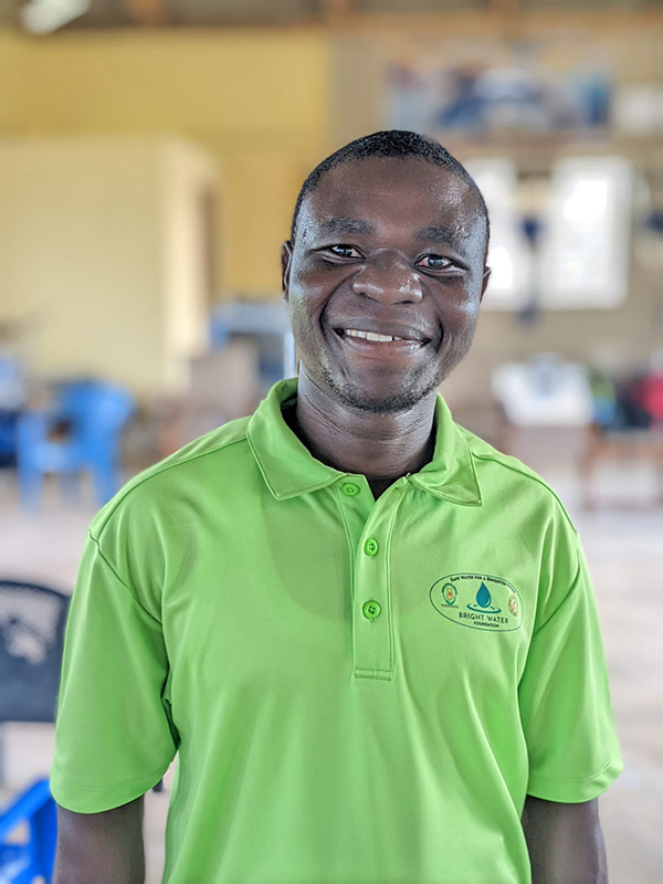 Smiling man in green Bright Water shirt.